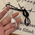 Minimalistische silberne Halskette mit klarem Kristall-Zapfenanhänger in der Hand - Transparent Wassertropfen (Mit Schwarzem Seil)