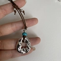 Close-up of adjustable necklace with vintage silver ring pendant and blue bead detail - Brown Rope with Green Bead and Hammered Ring Pendant