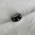 Detailed macro shot of adjustable black enamel ring with silver heart charms on white fabric - Black Multi-Heart Silver Decor Style