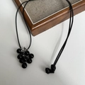 Minimalist long black cord necklace with glossy grape cluster pendant on wooden stand - Black Grape Cluster + Black Rope Necklace