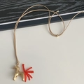 Collana chic con pony dorato, nappe di perline rosse e cordino marrone regolabile - Cavallo Oro Opaco Con Coda di Perline Rosse