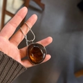 Macro shot of an amber resin irregular pendant with silver metal frame and snake chain - Coffee With Adjustable Steel Chain