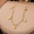 Gros plan d'un collier doré avec des breloques trèfle sur un présentoir à bijoux - Trèfle Creux (H1153) Or
