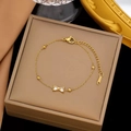 Detail eines vergoldeten Edelstahl-Armbands mit Schleifen-Anhänger und Karabinerverschluss - Zirkonia Schleifen Armband (Gold)