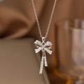 Elegante silberne Halskette mit Schleifenanhänger, weißen Perlen und funkelnden Zirkonen - Künstliche Perle Schleife (9006)