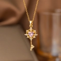 Gros plan du pendentif clé dorée avec pierre en cœur rose et détails en zircon - Clé Coeur (9105)
