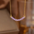 Detail of a gold smile necklace featuring 11 vibrant purple stones in a curved pavé setting - Gold Purple Zirconia