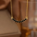 Detailed close-up of golden O-chain necklace featuring seven faceted black onyx beads - Gold Black Zirconia