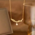 Detailed close-up of golden laurel leaf pendant with pear-shaped zircon and pave crystals - Wave Wrapped Water Drop (9167)