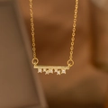Close-up of gold bar pendant necklace featuring seven sparkling round zircon stones - Horizontal Bar Dangle (9177)