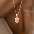 Close-up of elegant gold chain with a pink enamel strawberry pendant and zircon accents - Pink Strawberry (8280) / Gold