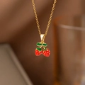 Macro d'un pendentif fraise rouge avec feuille verte et fine chaîne dorée élégante - Deux fraises (8283) / Or