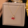 Detail shot of a titanium cherry pendant necklace in a beige jewelry presentation box - Double Cherry Pendant (8026) / Gold