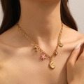 Golden stainless steel ocean themed necklace with shell star and dolphin charms for women - Necklace