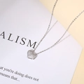 Detailed macro view of heart pendant necklace with shimmering cubic zirconia micro-paving - Silver