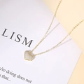 Macro shot of 14K gold-plated heart pendant with pave cubic zirconia on fine chain - Champagne Gold