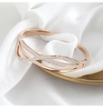 Detailed close-up of rose gold wave bangle with micro-pave zircons on silk background - Multi Layer Wave Style / Rose Gold