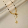 Detail of gold gourd necklace with Fu character charm on elegant satin background - Gold Gourd (Character Fu)
