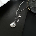 Macro shot of silver titanium necklace with rocking horse charm and white mother of pearl - Silver