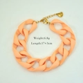 Details des orangefarbenen Acryl-Kettenarmbands mit Edelstahl-Herzanhänger in Gold - Orange