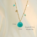 Detail der Goldkette mit blauem Herz-Edelstein und kleinen Sternanhängern auf Stoff - Amazonit