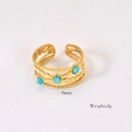 Detailed macro of a 9mm gold wavy open ring with three round turquoise stones - Amazonite