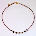 Detailed macro view of garnet beaded necklace with gold accents and natural raw stones - Irregular Raw Stone Beaded Style / Reddish Brown Faceted Bead Necklace
