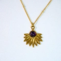 Makro-Detail des Bohème-Sonnenblumen-Anhängers mit lila Edelstein an Goldkette - Amethyst