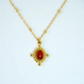 Close-up of vintage oval red gemstone pendant with ornate gold frame and beaded chain - Necklace / Red Agate Necklace