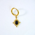 Macro view of gold hoop earring with blue stone cross pendant on white fabric - Black Agate Earrings