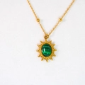 Makroaufnahme einer goldenen Edelstahl-Halskette mit Sonnenanhänger und Malachit-Stein - Sonnen-Malachit-Anhänger-Halskette (Malachit-Kette)