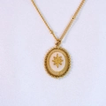 Detail of vintage gold oval pendant featuring a star pattern and beaded edge on bead chain - Gold - White Jade Necklace