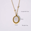 Macro detail of oval pendant necklace with twisted gold frame and white shell inlay - White Shell