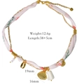Détail de breloques coquillage et perles sur un collier ruban fleuri rose et or - Style Coquillage Enveloppé de Foulard Satin Floral (XB2507004) / Rose Fleuri