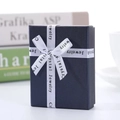 Navy blue jewelry gift box with white silk ribbon and elegant textured finish - Blue