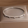 Vintage titanium steel bangle with five embossed X-cross motifs and polished silver finish - Crisscross X Element Style (B753 Silver)
