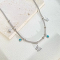 Detail of woven steel chain necklace with butterfly charms and blue turquoise beads - Silver Butterfly