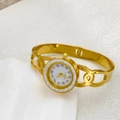 Detail of elegant gold hollow bangle watch with crystal bezel and quartz dial - Double C Hollow Style