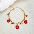 Detail view of a gold-tone stainless steel bracelet with red enamel apple charms - Apple Bracelet / Gold