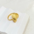 Close-up of golden adjustable ring with irregular wave texture on white stone stand - Heart Striated Style