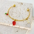 Detailed close-up of gold bow cuff with red strawberry and translucent butterfly charms - Strawberry Style (B1150)