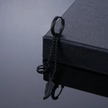 Macro detail of black stainless steel feather tassel earring on premium gift box edge - Piercing Style / Black Feather Dangle