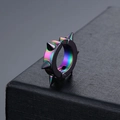 Detailopname van regenboogkleurige titaniumstalen spike-oorbel op zwarte lederen achtergrond - Kleurrijk