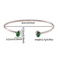 Macro di un bracciale rigido argento lucido con due pietre di zircone verde ovale - Stile Gemma Verde Scuro (ZHG2257) / Colore acciaio