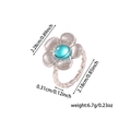 Macro view of flower-shaped ring with turquoise center and rope-textured silver band - Silver-Cyan Stone