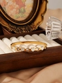 Dettaglio del bracciale a cuore in acciaio dorato con zirconi in una scatola regalo - Stile Cuore Bianco (ZHG598 Bianco) / Oro