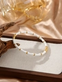 Detailed view of white and gold bamboo-style stainless steel bangle on display - White