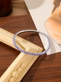 Detailed close-up of stretch zircon bracelet with purple crystals in silver claw setting - Purple