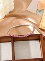 Detail of pink crystal tennis bracelet with silver metal base on silk background - Pink