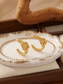 Detailed view of irregular gold-plated knot hoop earrings on an elegant vintage tray - Knot Design (ZHE2116) / Gold